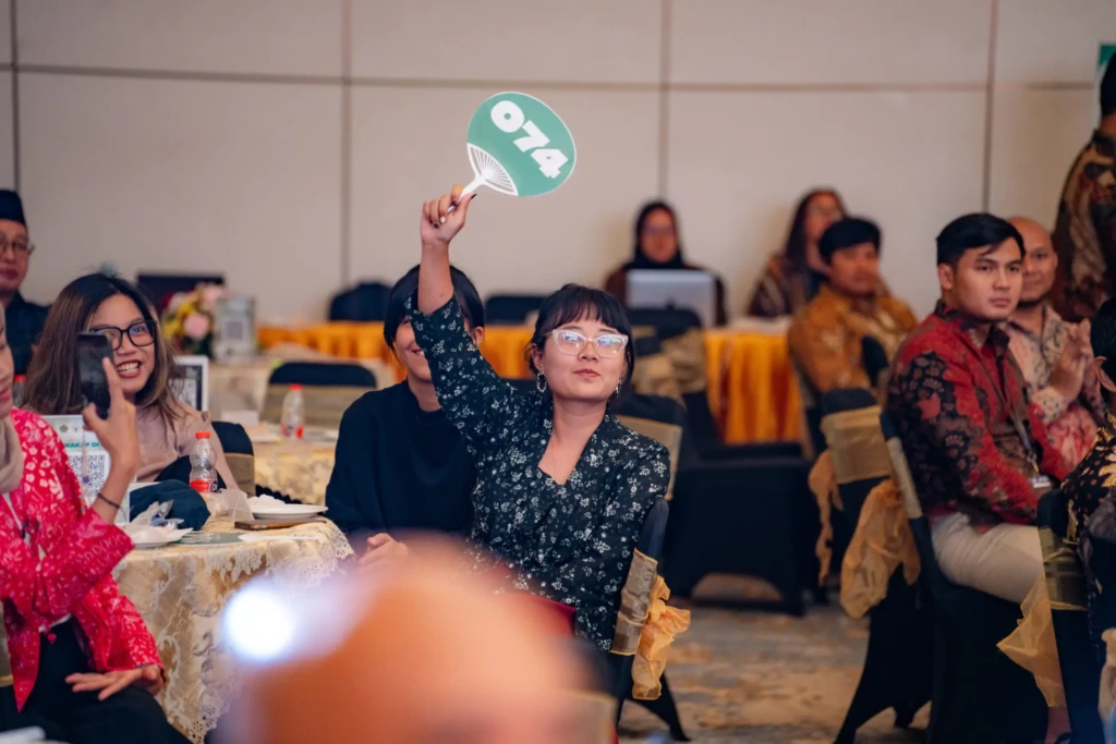 Audience at The Future Is Our Canvas event holding up green cards